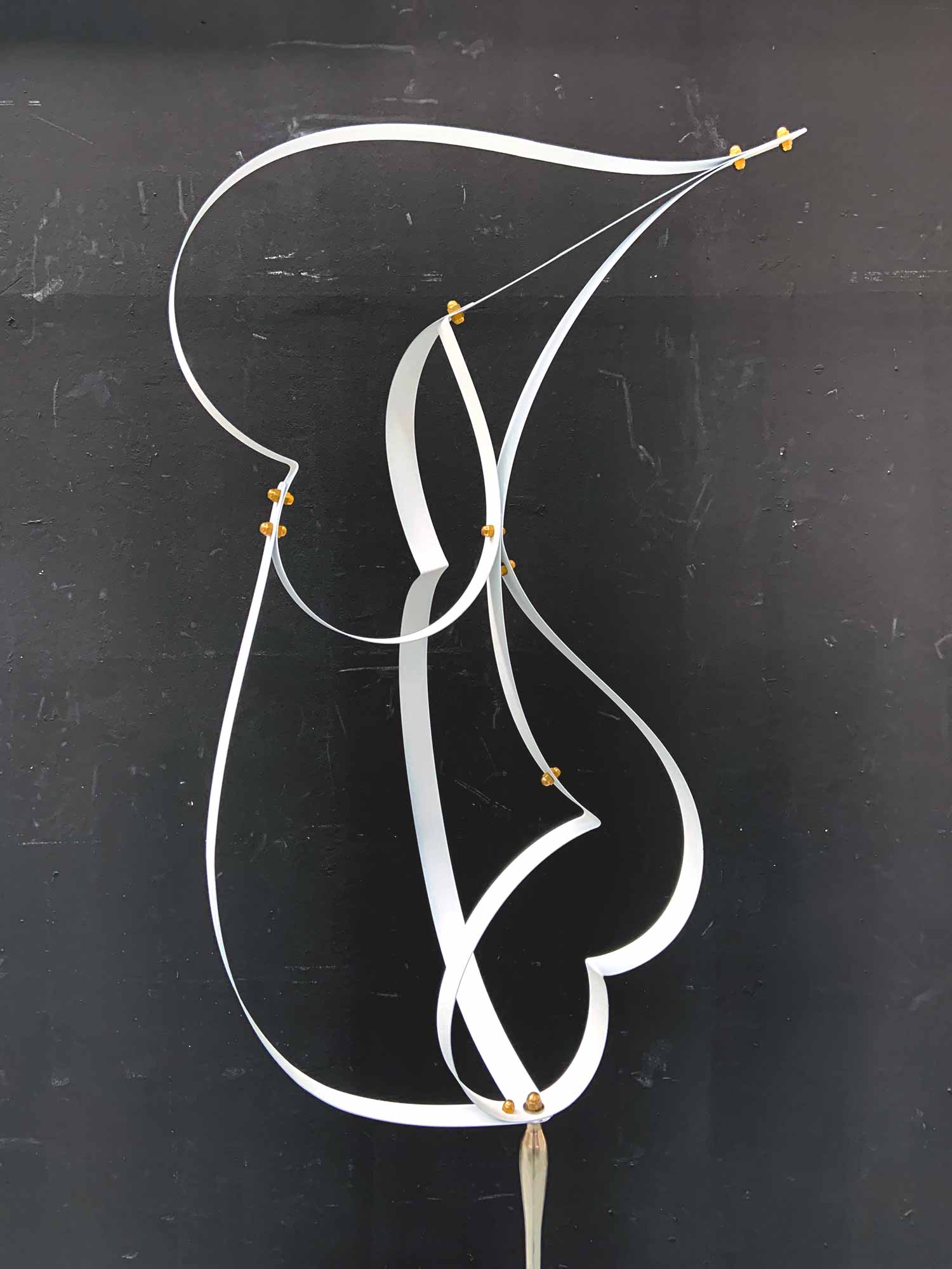 Escultura vertical feta amb tires de fleix blanc entrellaçat sobre base de ferro fos - detall