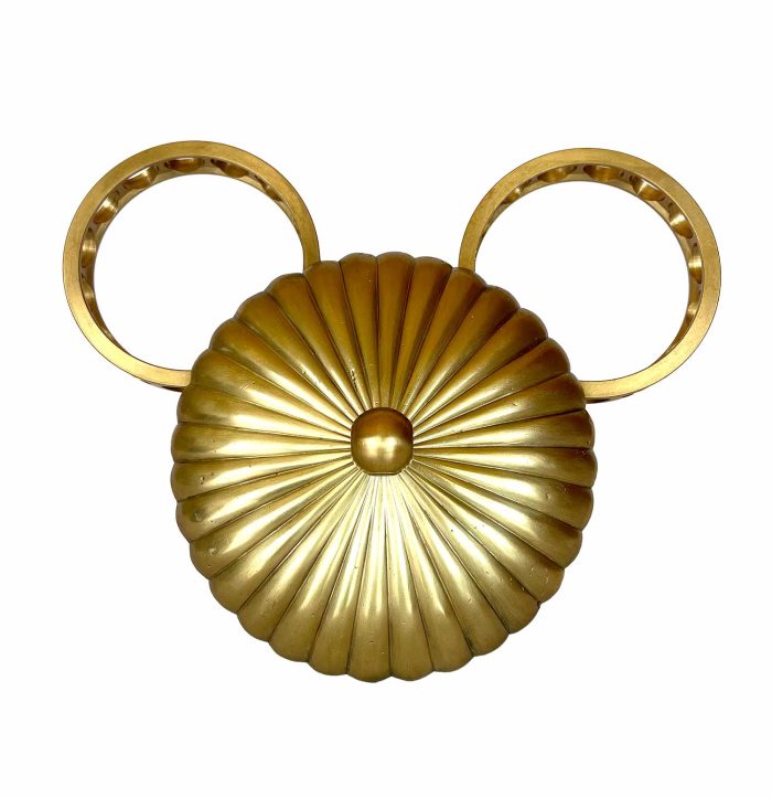 escultura de la cara del mickey per pensar a la pared i formada per una pera de lámpara amb ratllles radials com un sol i dos cercles industrials per orelles